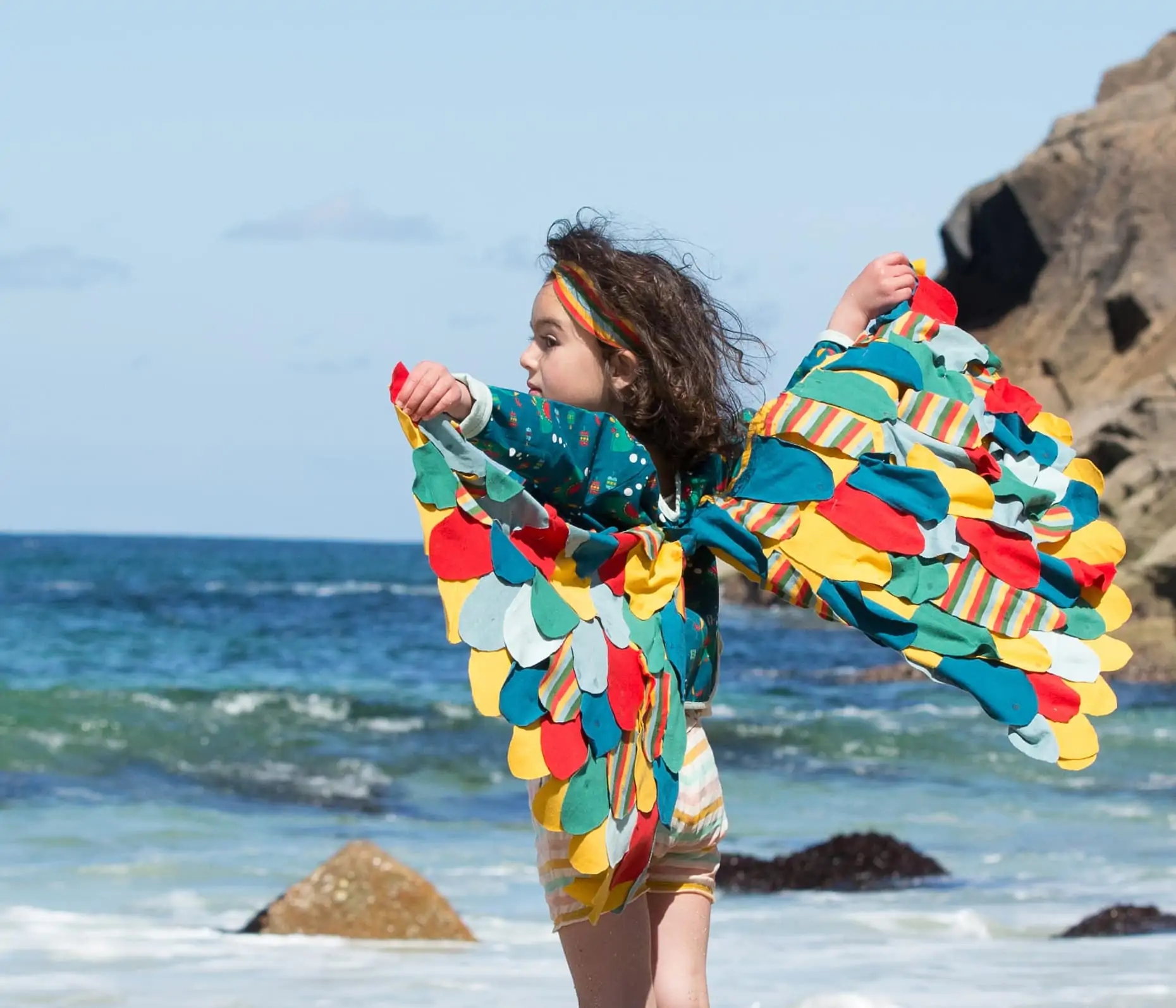 Child modelling Little Green Radicals clothes on a beach