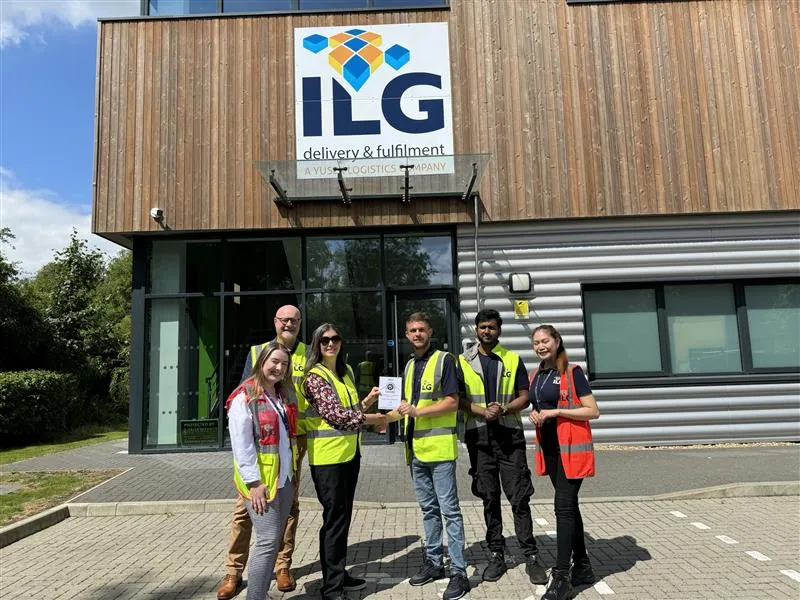 ILG staff with Clare Bottle holding certificate standing outside Salfords